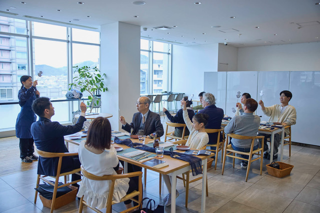 棒つきのイカを振る参加者たち（撮影：木寺紀雄） 